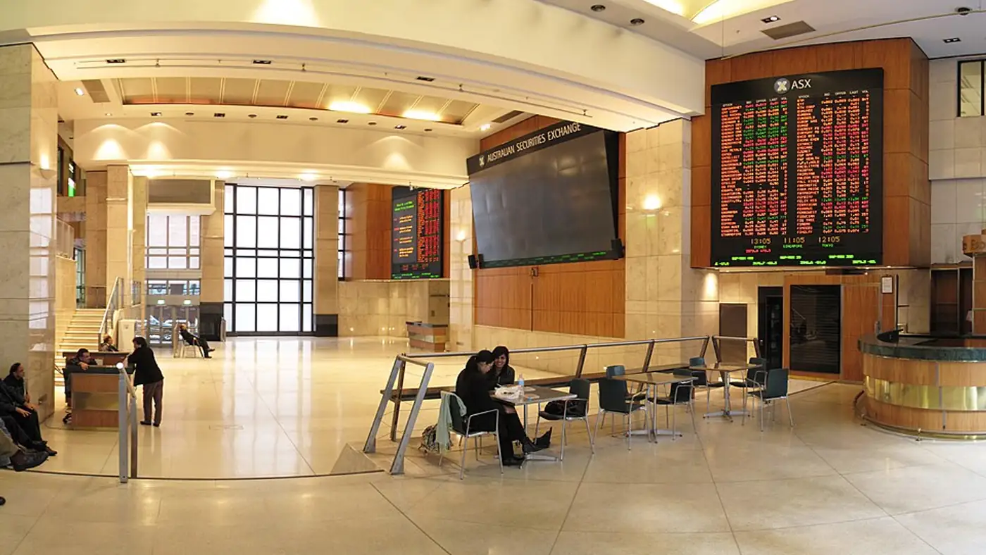 Trading floor screens showing the ASX 200 index at a record close
