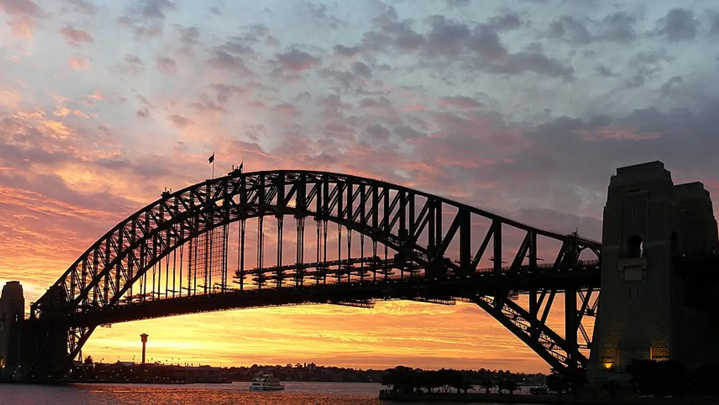 Harbour Bridge silhouetted against sunset sky from a cruise deck